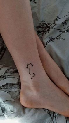 two people with matching tattoos on their feet are laying in bed and one is holding the other's leg