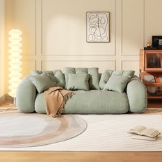 a living room with a couch, rug and book on the floor in front of it