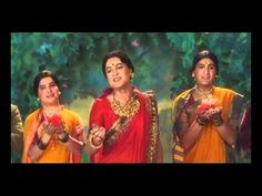 three women in yellow and orange saris holding small pots with flowers on their hands