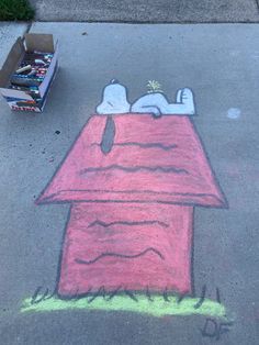 a chalk drawing of a doghouse with a person sleeping on top