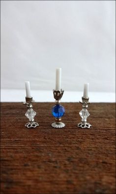 three silver candlesticks sitting on top of a wooden table