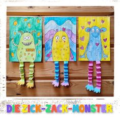 three paper monsters are hanging on the wall