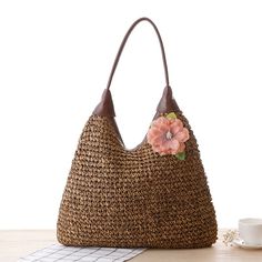 a brown purse sitting on top of a wooden table next to a cup and saucer