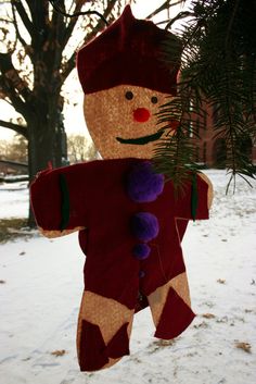 a christmas ornament hanging from a tree in the snow