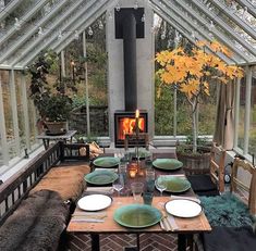 a table with plates and place settings in front of an open air fireplace that reads, beat the cold & heat insulate this greenhouse - like 3 season to