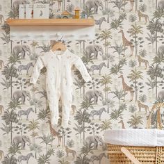 a baby's pajamas hanging on a wall next to a basket with an animal print