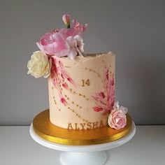 there is a cake with flowers on the top and gold trimmings around it