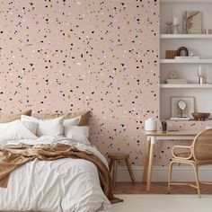 a bed sitting under a pink wall next to a white desk and chair in a bedroom