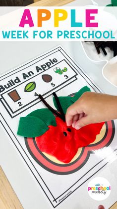 an apple is cut into pieces with scissors and paper on the table next to it