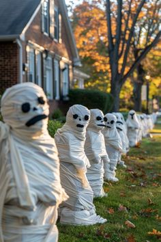 there are many wrapped up ghost statues in front of the house on this halloween day