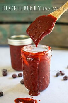 a wooden spoon full of jam on top of a table