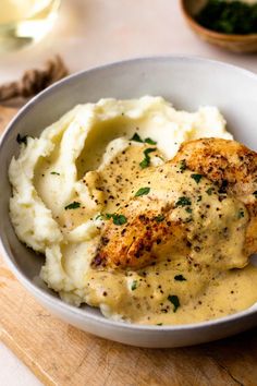 a white bowl filled with mashed potatoes and chicken