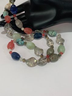 This is a vintage artisan made barrel shaped polished gemstones with glass leaves and pink crystals accent. Array of colorful faceted pink quartz, jasper, calcite, green aventurine, kiwi stone to name some of them., It measures 28 1/2 inches long, from end to end. Silver tone hook clasp. Each stone is unique and beautiful so please expect slight variations in color, texture, and size. Excellent vintage condition! PLEASE look at ALL pictures for measurements and condition as they are a very impor Natural Stones Czech Glass Beads For Jewelry Making, Bohemian Faceted Beads For Jewelry Making, Czech Glass Natural Stones For Jewelry Making, Handmade Multicolor Mineral Crystal Necklace, Unique Czech Glass Beads With Natural Stones, Luxury Multi-stone Beaded Necklace With Round Beads, Vintage Multi-strand Gemstone Beads Necklace, Nature-inspired Multicolor Gemstone Beads Necklace, Polished Gemstones