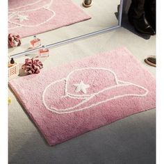 a pink rug with a cowboy hat on it in front of a mirror and shoes