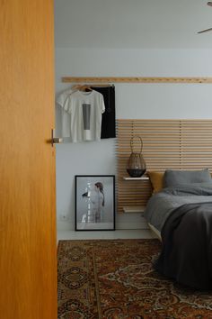 a bed room with a neatly made bed and a wooden headboard on the wall