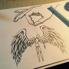 a drawing of an angel being held by a person's hand over a piece of paper