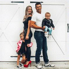 a man, woman and two children standing in front of a garage door