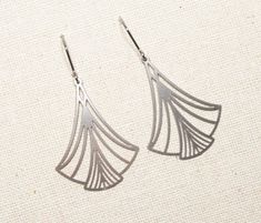 For me, the Art Deco style (ca. 1920-1940) is just the right mix of strict geometry and delicate playfulness - that's why I love using these shapes in my jewelry. This is also the case with these silver-colored stainless steel earrings. They consist of a fan-shaped element that is not exactly small, but nevertheless appears very delicate and airy thanks to its filigree shapes. The ear hooks are also made of hypoallergenic stainless steel and are therefore also suitable for more sensitive ears. T Art Deco Silver Brass Jewelry, Silver Art Deco Brass Jewelry, Contemporary Silver Jewelry With Artistic Design, Elegant Handmade Stainless Steel Earrings, Modern Metal Jewelry With Artistic Design, Elegant Adjustable Geometric Earrings, Modern Nickel-free Wedding Earrings, Art Deco Earrings With Polished Finish, Elegant Metal Jewelry With Artistic Design