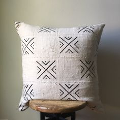 a black and white pillow sitting on top of a wooden chair