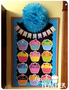 a bulletin board with cupcakes on it and a blue pom - pom