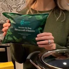 a woman holding a bag of broccoli florets