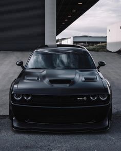 a black car parked in front of a garage