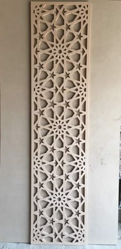 an intricately carved wall panel in the shape of a trellis, on display