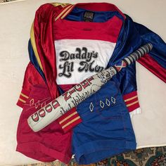 a baseball uniform and bat laying on top of a bed