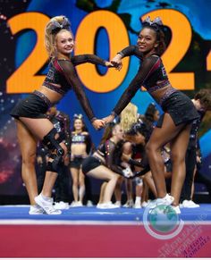 two cheerleaders are dancing on the stage