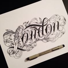 an ink drawing of the word cotton on paper with a marker and pen next to it