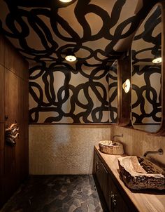 an artisticly designed bathroom is shown in this image, with two sinks and mirrors on the wall