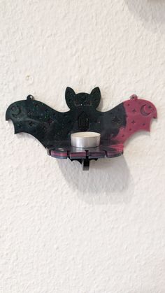 a bat shaped candle holder on the wall