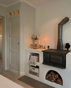 a room with a fireplace and some candles on the mantle next to a bed in it