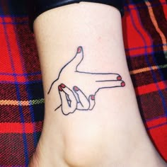 a woman's foot with a tattoo on it that has two fingers pointing towards each other