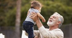 an older man holding a toddler up to his face