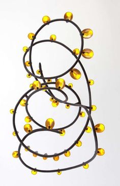 a bunch of yellow balls hanging from the side of a wall in front of a white background