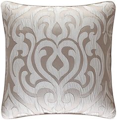 a white and grey pillow with an intricate design on the front, sitting against a white background