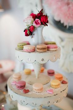 three tiered cake stand with macaroons and roses