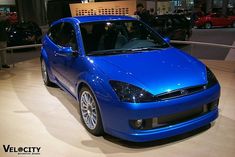 a blue car is on display at an auto show