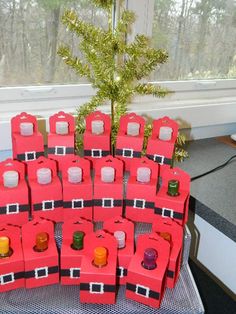 a bunch of red boxes sitting on top of a table next to a christmas tree