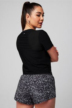 a woman in black shirt and patterned shorts