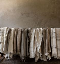 several pieces of cloth hanging on a clothes line in front of a wall with a light colored background