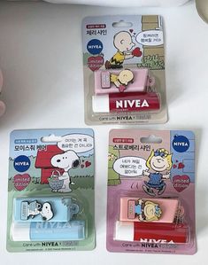 three cartoon characters are in plastic packaging on a white surface, one is holding a cell phone and the other has a clip attached to it