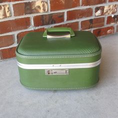 This vintage hard side 1960s train case is a gorgeous avocado green color.  Condition is quite nice -minimal scuffs/ scratches on the nicely pebble textured exterior and mirror is in nice condition with no chips or cracks.  Interior is quilted green satin lining (some water marks/ dings) with an elasticized pocket.  There are four metal feet (some patina) on the bottom. Measurements are approximately 13 1/2" x 9" x 7 1/2".  What a stylish way to carry makeup, use as an overnight bag, or carry on Retro Luggage, Vintage Train Case, Green Quilt, Vintage Train, Train Case, Vanity Case, Avocado Green, Green Satin, Makeup Case