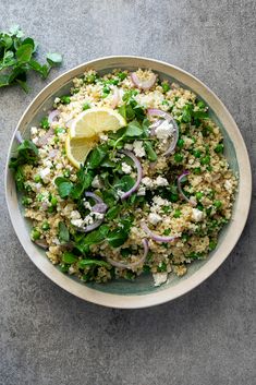 a white bowl filled with food next to a lemon wedge and parsley on the side