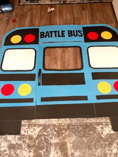 a cardboard battle bus sitting on top of a wooden floor