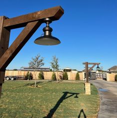 a lamp hanging from the side of a wooden structure in a yard next to a fence