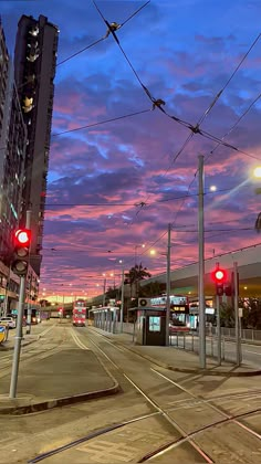 an empty city street at dusk with red traffic lights and buildings in the back ground