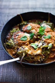 a skillet filled with food on top of a wooden table