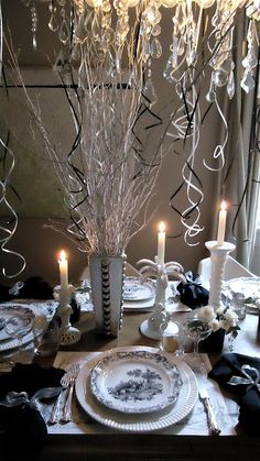 a dining room table set with plates and candles